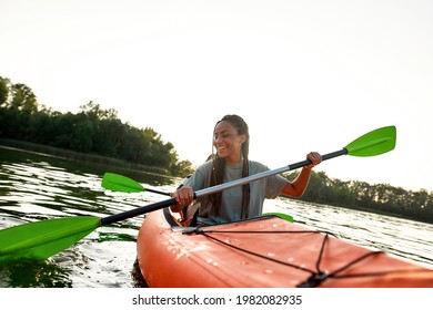 Joyful young woman smiling, enjoying a day kayaking together with her friend in a lake on a late summer afternoon. Kayaking, travel, leisure concept - Powered by Shutterstock