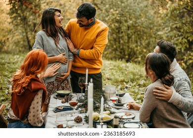 The joyous ambiance of a garden party, with a couple proposal with a diverse group of people relishing a shared meal amidst nature's beauty. - Powered by Shutterstock