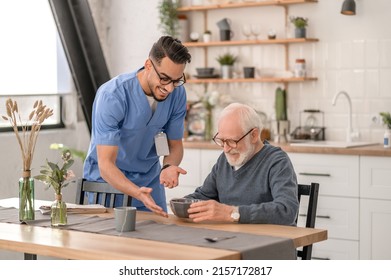 Joyous amiable volunteer serving the meal to an aged man - Shutterstock ID 2157172817