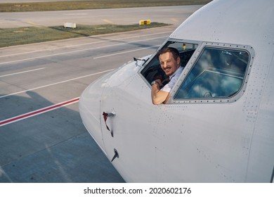 Joyous aviator posing for the camera from the flight deck