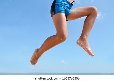 The joyous boy jumped on the seashore. Feet of a young boy in a jump , against the blue sky, on the beach. Concept: success, joy. Enjoy your vacation, vacations. - Shutterstock ID 1663765306