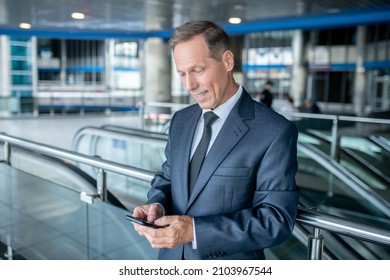 Joyous Businessperson Reading A Text Message On His Cellphone