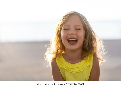 Joyous Cute Little Girl Laughing Hysterically Outdoors