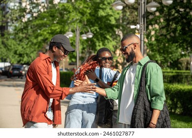 Joyous hello of african american friends on street. Happy group of black students with good mood embrace each other as meet to spend time together.Two guys shake hands, girls smile hug, see each other - Powered by Shutterstock