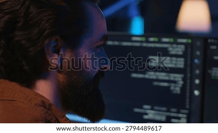 Joyous remotely working programmer in home office doing coding on computer at desk.