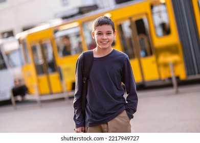 Joyous teen posing for the camera against the public transport - Shutterstock ID 2217949727