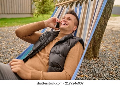 Joyous Vacationer Having A Phone Conversation Outdoors