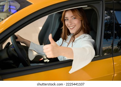 Joyous woman approving her new automobile before camera - Shutterstock ID 2225441107