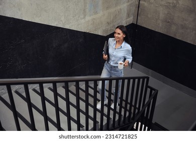 Joyous woman walking up stairs during tea break