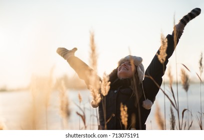 Joyous Young Woman With Her Arms Raised Up