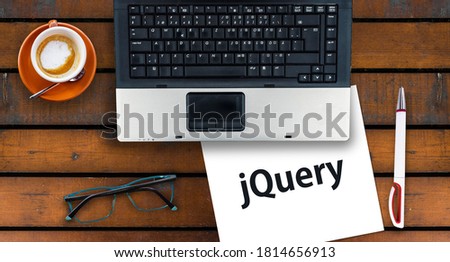 jQuery. Paper width word jQuery and laptop, glasses and coffee on wooden table