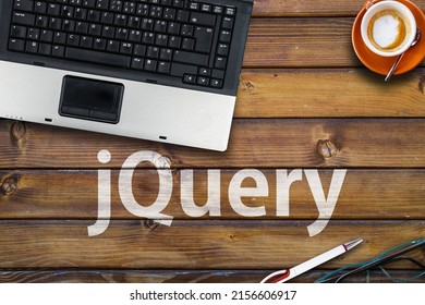 jquery. Word jquery, laptop, glasses and coffee on wooden table
					