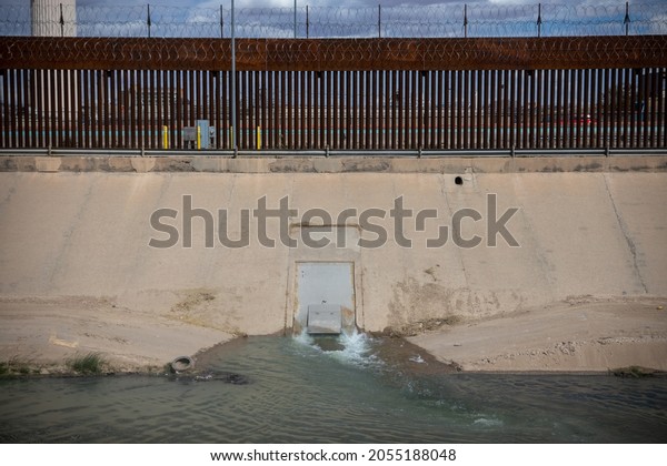 \
Juarez Chihuahua\
Mexico, 26-09-2021 wall that divides Mexico from the United States,\
drainage is discharged over the Rio Grande natural border Mexico\
United States. \

