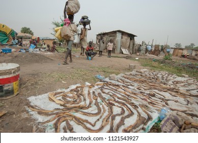 JUBA, SOUTH SUDAN - FEBRUARY 28 2012: Unidentified Women Pass By Butcher Waste Dried For Eating In Refugee Camp, Juba, South Sudan. Refugees Stay In Harsh Conditions In Displaced Persons Camp Of Juba.