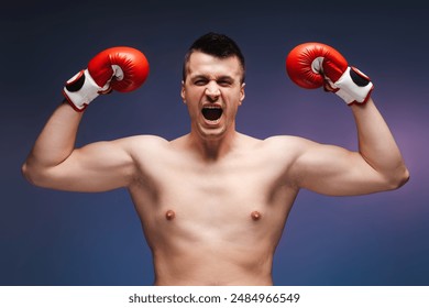 Jubilant boxer celebrates victory with raised red gloves, showcasing strength and determination against a blue background - Powered by Shutterstock
