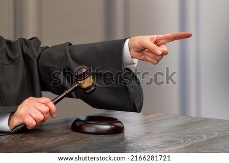 Judge banging judge's gavel index finger pointing. Law Lord wearing gown using a hammer for attention and verdict, justice judgment at courts of law cropped view.