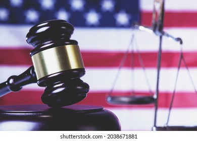 Judge gavel against United States national flag as symbol of judicial system of the USA. Concept: justice, equity, law and human freedom. Close up.