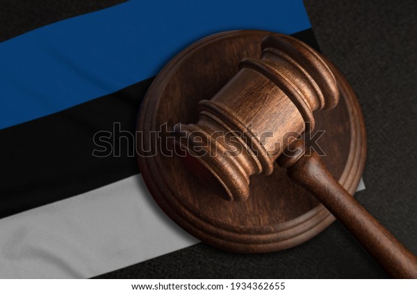 Judge gavel and flag of Estonia. Law\
and justice in Estonia. Violation of rights and\
freedoms.