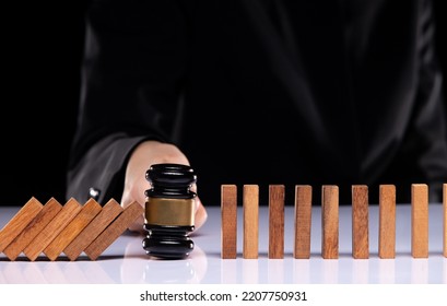 Judge gavel hand stop domino continuous tipping risk. Law crisis and crime increase stop problem falling with success effective Law enforcement and authority solving opportunity concept, copy space  - Shutterstock ID 2207750931