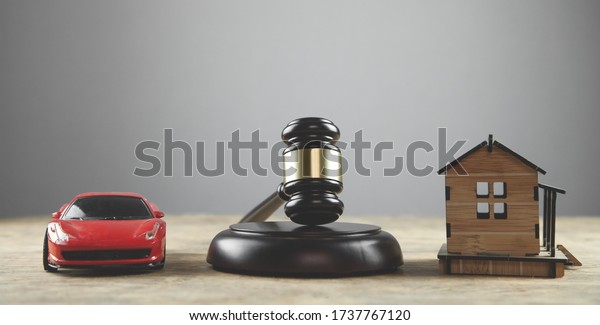 Judge gavel\
house and car on the wooden\
table.