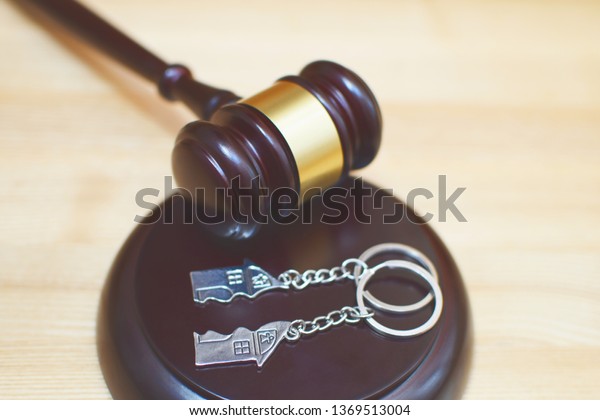 Judge gavel and key ring in shape of two
splitted part of house on wooden background. Concept of real estate
auction or dividing house when divorce, division of property and
real estate, law
system.
