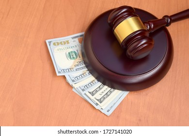 Judge Gavel And Money On Brown Wooden Table. Many Hundred Dollar Bills Under Judge Malice On Court Desk. Judgement And Bribe