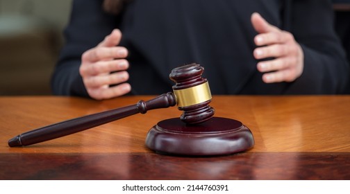 Judge Gavel On Wooden Law Court Bench, Blur Female Hands, Close Up View. Justice And Punishment Concept