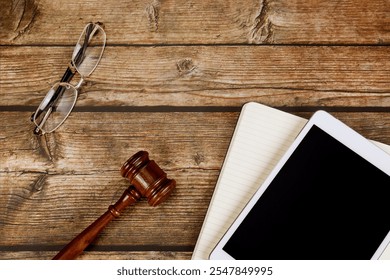 Judge gavel rests on wooden desk long side glasses, digital tablet PC, representing intersection of law technology in professional environment. - Powered by Shutterstock