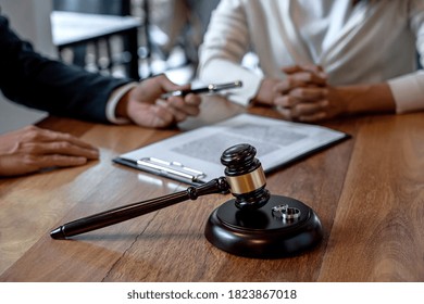 Judge gavel and two golden marriage ring, Contract decree of divorce (dissolution or cancellation) of marriage, husband and wife during divorce process and signing of divorce contract. - Shutterstock ID 1823867018