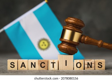 Judge gavel, wooden cubes with the text on the background of the Argentine flag, the concept on the topic of sanctions in Argentina - Shutterstock ID 2078080156
