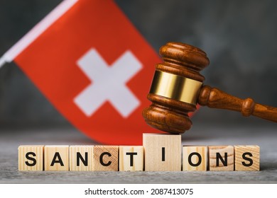 Judge gavel, wooden cubes with text and a flag on an abstract background, a concept on the topic of sanctions in Switzerland - Shutterstock ID 2087413075