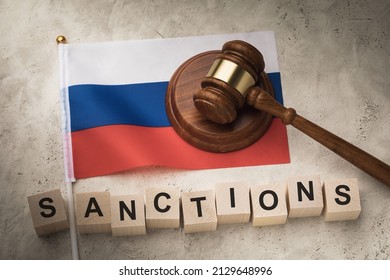Judge gavel, wooden cubes with text and flag of Russia on an abstract background, a concept on the topic of sanctions in Russia