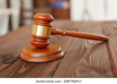 Judge hammer against the background of the courtroom. Judge gavel. Small ceremonial mallet made of hardwood. Court hammer. Judge mallet is a symbol of the authority. Justice symbol. Low concept