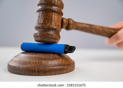 Judge hammering disposable vape with referee's gavel on white table.  - Shutterstock ID 2181151675