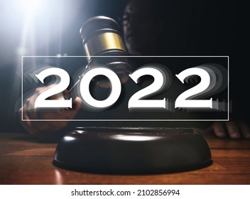 Judge hitting Gavel off a block in courtroom, dark background - year 2022 - change of law concept