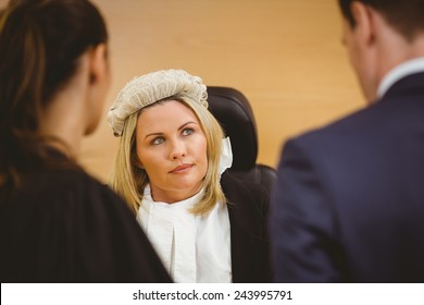 Judge and lawyer listening the criminal in handcuffs in the court room