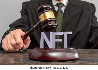 Judge and NFT non-fungible token concept. Judge's gavel on the table. Law Lord wearing gown using a hammer for verdict. Legalization of Internet trade in virtual goods and art.