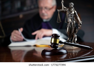 Judge Reading The Case File Beside Gavel And Statue Of Justice. Law Concept.