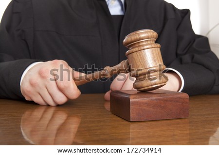 Judge. Referee hammer and a man in judicial robes