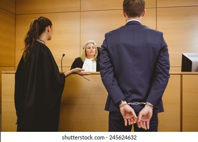 Judge Talking With The Criminal In Handcuffs In The Court Room