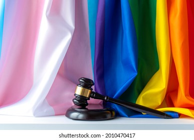 Judge Wooden Mallet, Rainbow And Transgender Flags As Symbol Of Tolerance On White Desk And Wall, Concept Picture About Human Rights, Space For Text	