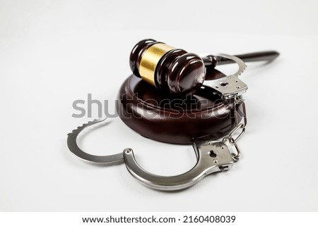 judge's gavel and handcuffs on a white background