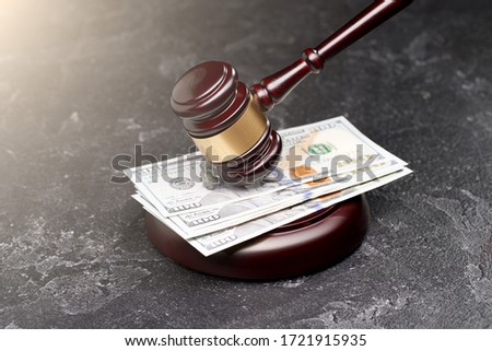 Judge's hammer, banknotes on black background