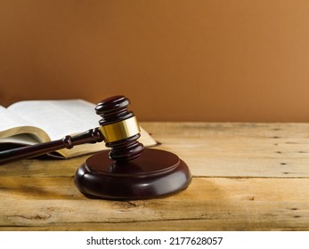 Judgment And Justice. Judge's Gavel On A Wooden Table And An Open Book On A Beige Background. Rule Of Law, Fair Trial, Constitution, Presumption Of Innocence.