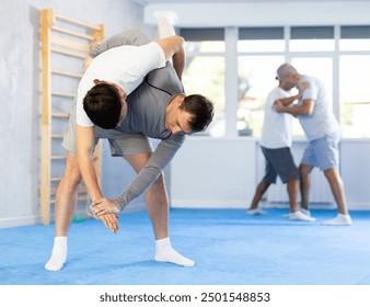 Judo lessons - young guy makes a power throw during judo or sambo classes - Powered by Shutterstock