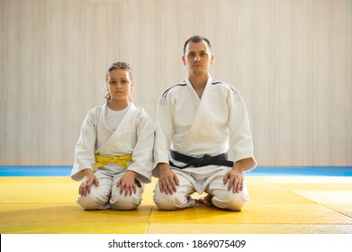 Judo master and young yellow belt judo girl in white judogi kneeling  - Powered by Shutterstock