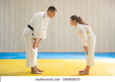 Judo master and young yellow belt judo girl in white judogi 