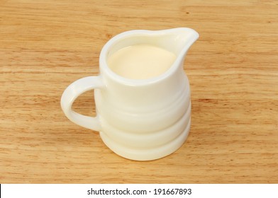 Jug Of Cream On A Wooden Board