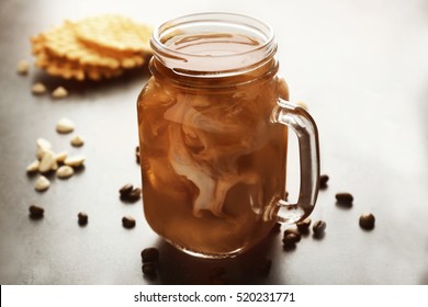 Jug With Delicious Iced Coffee And Wafers On Grey Background