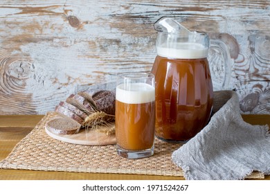 A jug and a glass of homemade bread kvass. Summer carbonated soft drink. Traditional cold drink Kvass in a jug.